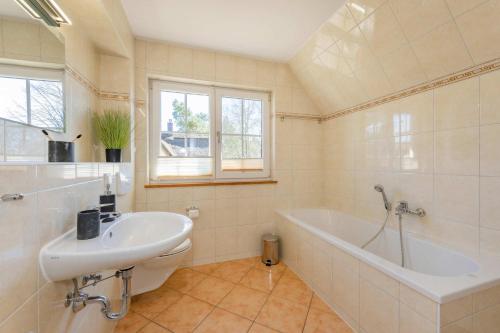 a bathroom with a bath tub and a sink at Ferienhaus "Ferien am Haff" in Zirchow
