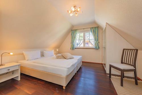 a bedroom with a bed and a chair and a window at Ferienhaus "Ferien am Haff" in Zirchow