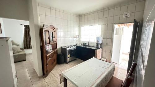 a small kitchen with a sink and a stove at Casa de piscina em Delfinopolis área central 2 suítes in Delfinópolis
