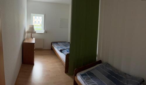 a small room with two beds and a window at Ferienwohnung Hainspitz Longstay in Hainspitz