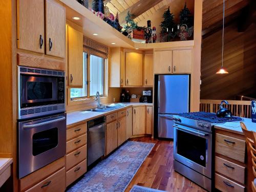 a kitchen with stainless steel appliances and wooden cabinets at 6 Colonial Lane in Sunriver