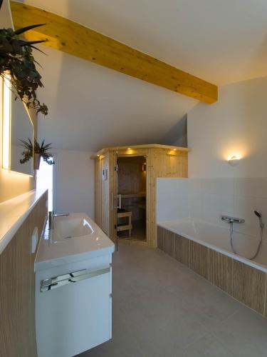 a bathroom with a bath tub and a sink at Ferienhaus Das Petermännchen in Fehmarn