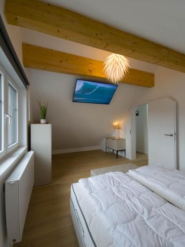 a bedroom with a large white bed and a window at Ferienhaus Das Petermännchen in Fehmarn