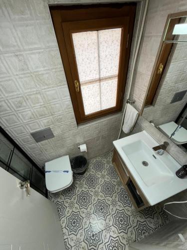 a bathroom with a sink and a toilet and a mirror at Lokal Ayvalık Guest House in Ayvalık
