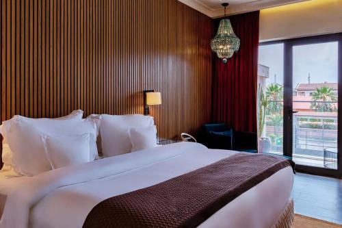 a bedroom with a large bed and a large window at D'avenue Boutique Hotel Accra in Accra