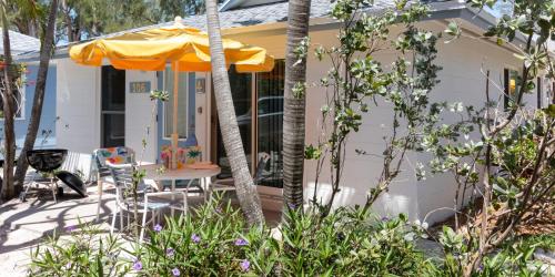 a house with an umbrella and a table and chairs at Bamboo Apartments in Holmes Beach