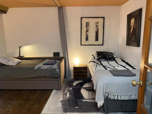 a bedroom with two beds and a cat sitting on the bed at Creative Norfolk Chapel with Piano and Sauna Sleeps 10 in Briston