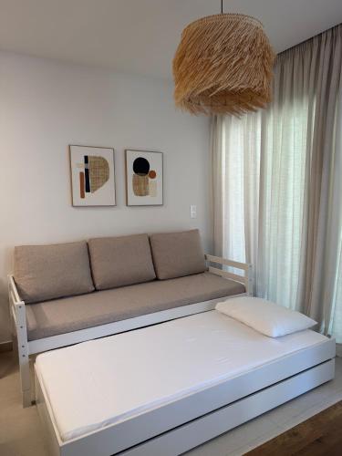 a couch in a living room with a large window at Notos Blue in Tsoutsouros