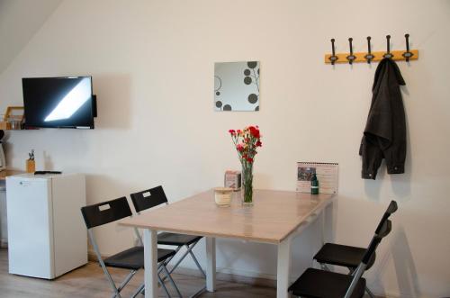 a dining room table with a vase of flowers on it at Le Relais de Poste in Orbigny
