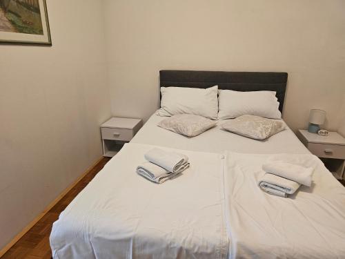 a white bed with two towels on top of it at Apartman u Velikoj Gorici Željko in Velika Gorica