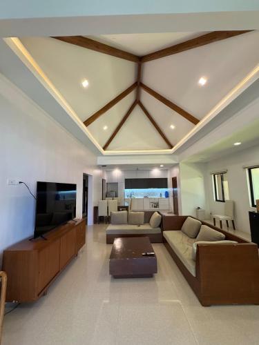 a large living room with a couch and a tv at Casa G in Bacong