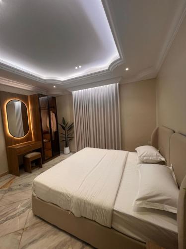 a bedroom with a large bed and a mirror at luxury rooftop apartment in Jeddah