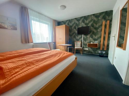 a hotel room with a bed and a television at Zum Schlossgarten in Ralswiek