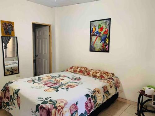 a bedroom with a bed and a painting on the wall at Hostal Inmaculada in Concepción de Ataco