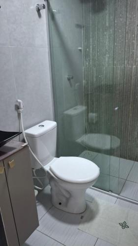 a bathroom with a toilet and a glass shower at Flat 205 Zuppolini in Bananeiras