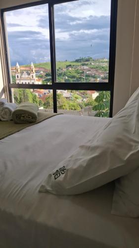 a bed in a room with a large window at Flat 205 Zuppolini in Bananeiras