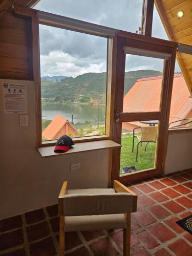 a window in a room with a view of a lake at Alpine Lake Lodge Hotel in Cajamarca