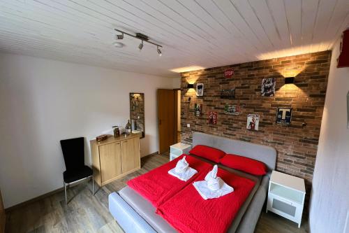 a bedroom with a red bed and a brick wall at Die Panorama-Wohnung-im-Grünem in Allensbach