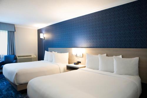 a hotel room with two beds and a blue wall at The Fredericton Inn in Fredericton