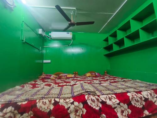 a green bedroom with a large bed with a green wall at Linga Wooden Room Second floor in Kanchipuram