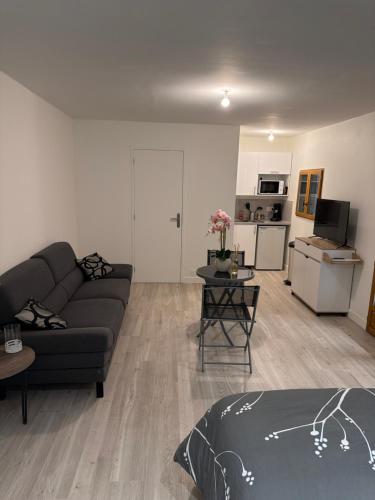 a living room with a couch and a kitchen at Studio, atypique in Chaufour-lès-Bonnières