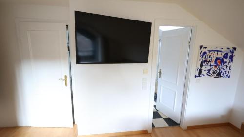 a flat screen tv on top of a white door at Vienna Woods Residence in Gaaden