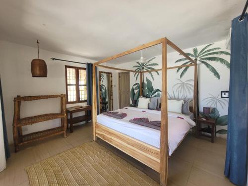 a bedroom with a canopy bed with palm trees on the wall at Lõst Soles Lodge in Jambiani