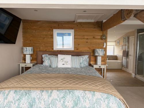 a bedroom with a bed and a television and a tub at The View in Criccieth