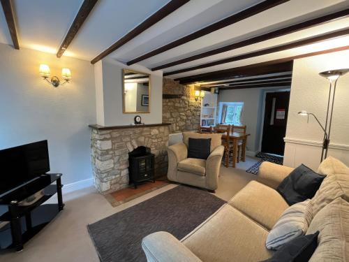 a living room with a couch and a fireplace at Little Ivy in West Lulworth