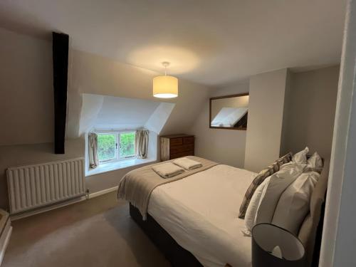 a bedroom with a bed and a window at Little Ivy in West Lulworth