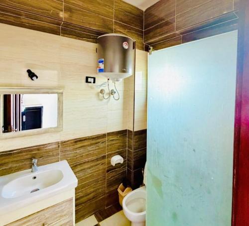 a bathroom with a sink and a toilet and a mirror at Santa Maria Dahab Hotel in Dahab