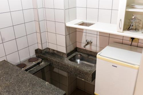 a small kitchen with a sink and a counter at Solar Flat Hotel in Juiz de Fora