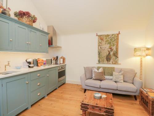 a living room with a couch and a table at The Little Loft in Burford