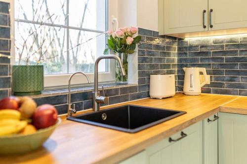 a kitchen counter with a sink and a bowl of fruit at Ágnes Villa Balatonföldvár in Balatonföldvár