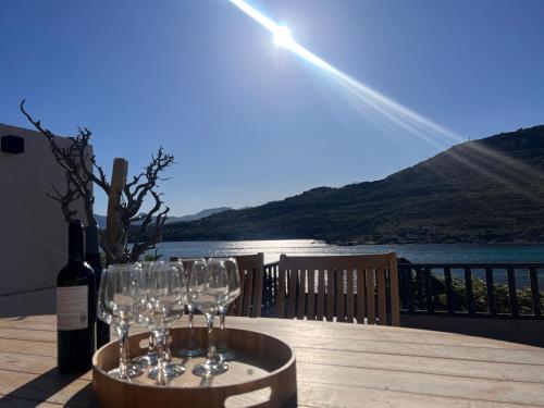a table with wine glasses and a bottle of wine at villa rêve in Calvi