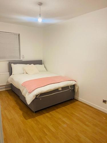 a bedroom with a bed in the corner of a room at 8 mins Drive from Heathrow - Double bedroom in shared accommodation - Cavalier Gardens in Hillingdon
