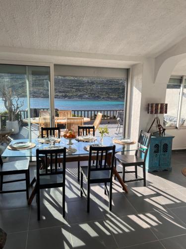 a dining room with a table and chairs and the ocean at villa rêve in Calvi