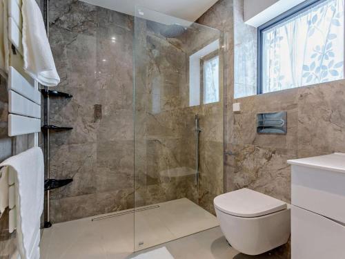 a bathroom with a toilet and a glass shower at 1 Bed in Isle Of Skye oc-96201 in Glendale
