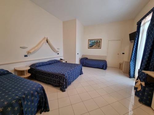 a hotel room with two beds and a television at Hotel Azzurra in Lido degli Estensi