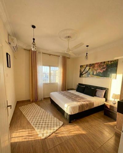 a bedroom with a large bed and a window at CozyQ Apt in Aqaba