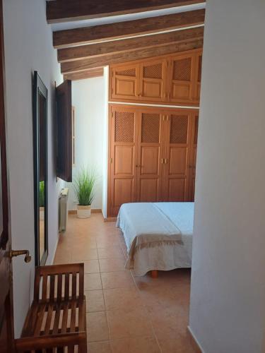 a bedroom with a bed and a wooden door at Casa Alacantí in Pollença