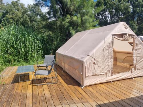 ein Zelt und ein Stuhl auf einem Holzdeck in der Unterkunft La tente de Tom in Salazie