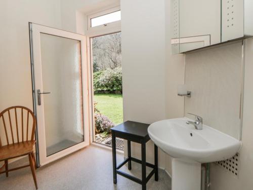 a bathroom with a sink and a sliding glass door at Riverside Cottage in Llandrindod Wells