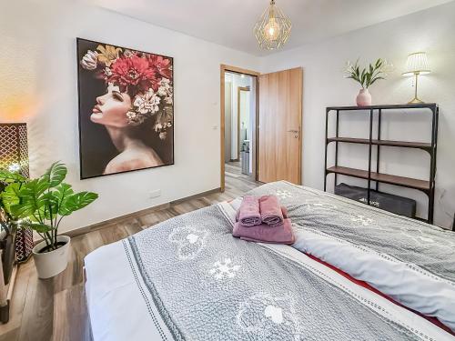a bedroom with a large painting on the wall at Apartment Lotus in Ovronnaz