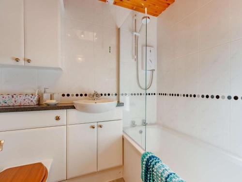 a white bathroom with a sink and a shower at 3 Bed in Crieff oc-88631 in Comrie