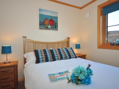 a bedroom with a bed with a blue flower on it at 4 Bed in Gairloch oc-29010 in Gairloch
