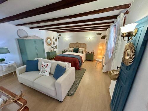 a bedroom with a bed and a white couch at Balcón Néstor Álamo I in Tejeda