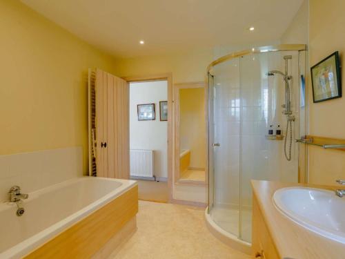 a bathroom with a tub and a shower and a sink at 5 Bed in Aberlour oc-ca280 in Carron