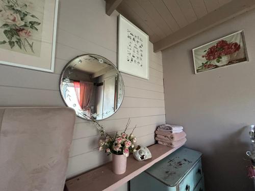 a mirror sitting on a shelf in a room at The Dairy stylish chalet for 2 opp the beach 1 minute walk in Whitstable