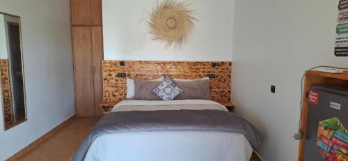 a small bedroom with a bed and a brick wall at Darna 2 in Demina